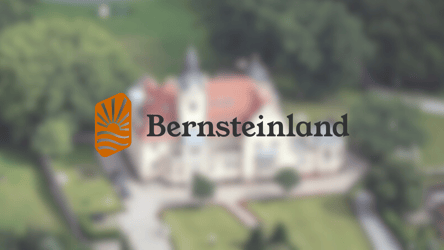 Titelbild der Referenz "Website für Bernsteinland" von Digitalagentur viminds. Im Hintergrund ein Gutshaus aus der Luftperspektive. Im Vordergrund das Logo von Bernsteinland