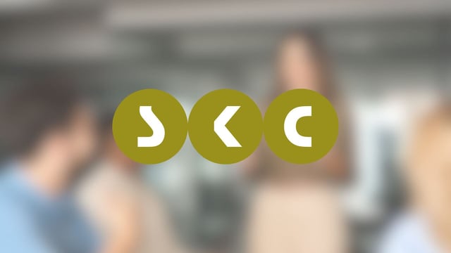 Referenzbild für Prozessoptimierung durch HubSpot bei der SKC Beratungsgesellschaft mbH. Foto eines Beratungsgespräches von SKC im Hintergrund. Im Vordergrund das Logo von SKC.