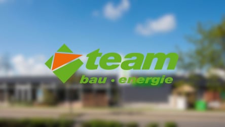 Referenzbild für die Performance Marketing Kampagne für Team Baucenter. Im Hintergrund ein Firmengebäude. Im Vordergrund das Logo von Team Baucenter.