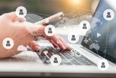 Person am Laptop mit Smartphone und Vernetzungs-Grafik im Vordergrund Person am Laptop mit Smartphone und Vernetzungs-Grafik im Vordergrund