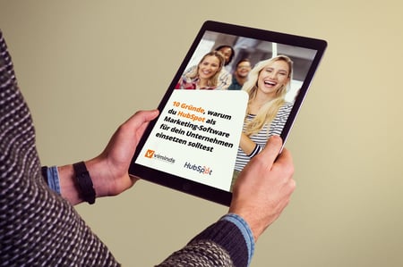 Mann hält ein Tablet mit dem HubSpot-Guide in der Hand