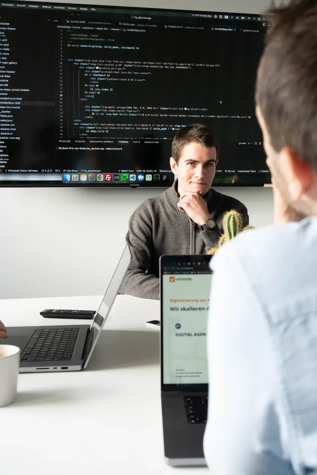 Das Bild zeigt zwei Mitarbeiter unserer HubSpot Agentur in Dresden im Austausch über HubSpot Development, Schnittstellen bzw. API relevanten Themen.