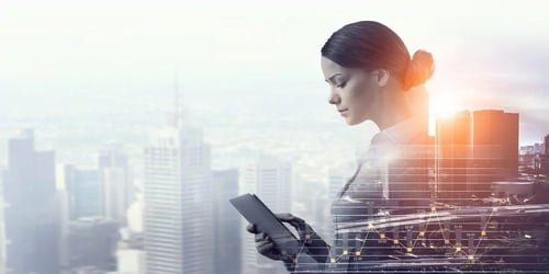 Frau mit Tablet mit Skyline im Hintergrund