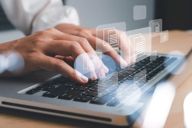 Person am Schreibtisch mit Laptop und Grafiken im Vordergrund Person am Schreibtisch mit Laptop und Grafiken im Vordergrund